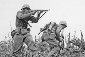 historic black and white photo of two soldiers in battle with one aiming a rifle