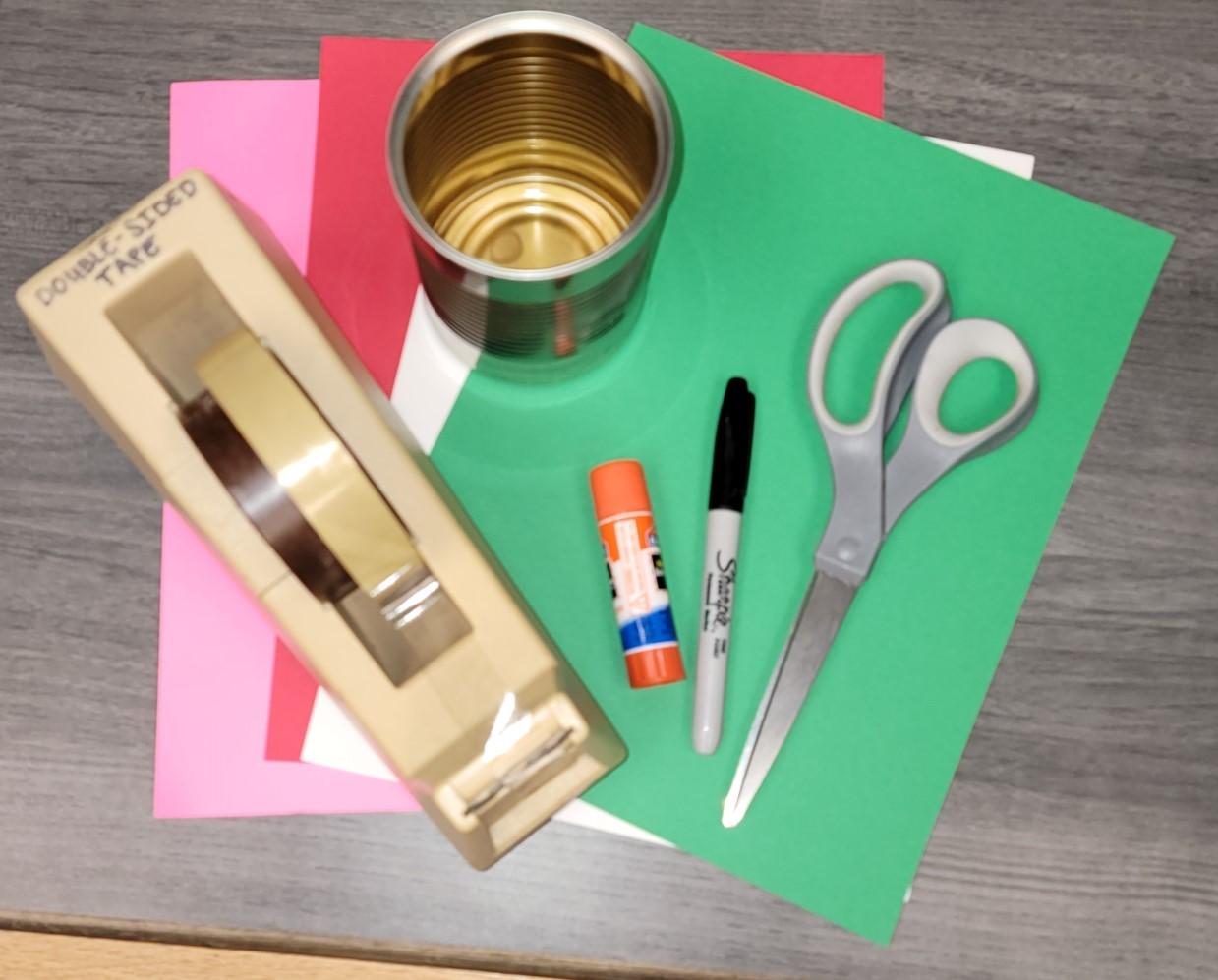 Tin can, scissors, double-stick tape, glue stick, black marker, colored paper.