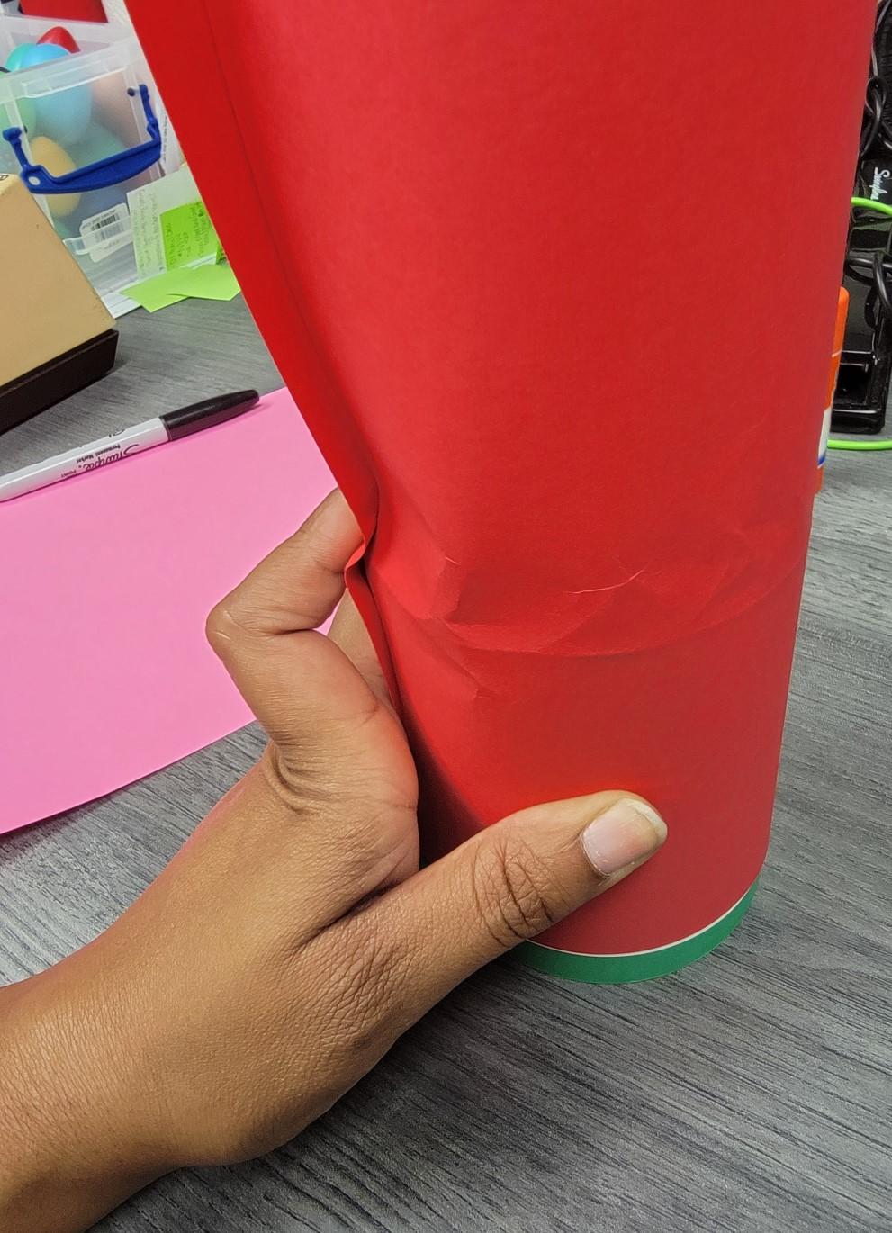 Paper wrapped around the tin can showing indention where paper has been pressed along the can's top edge.