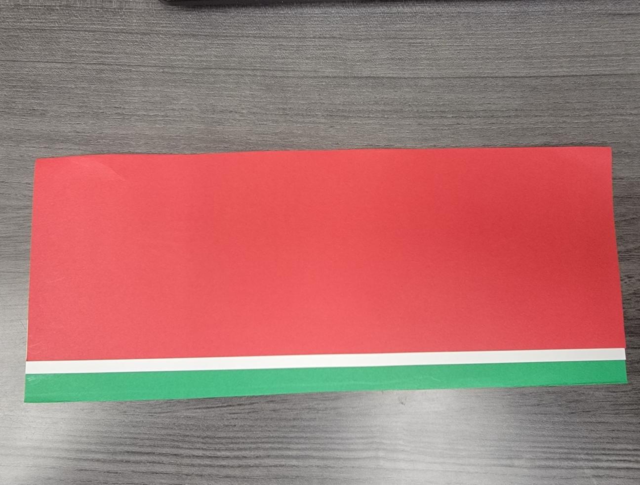 Excess has been cut from the top edge of the red paper.