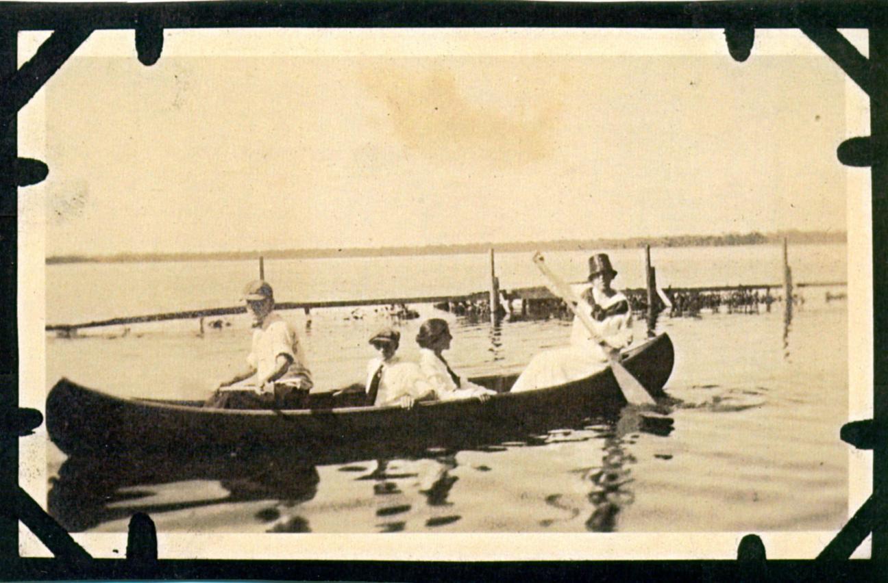 four people in a canoe on a lake