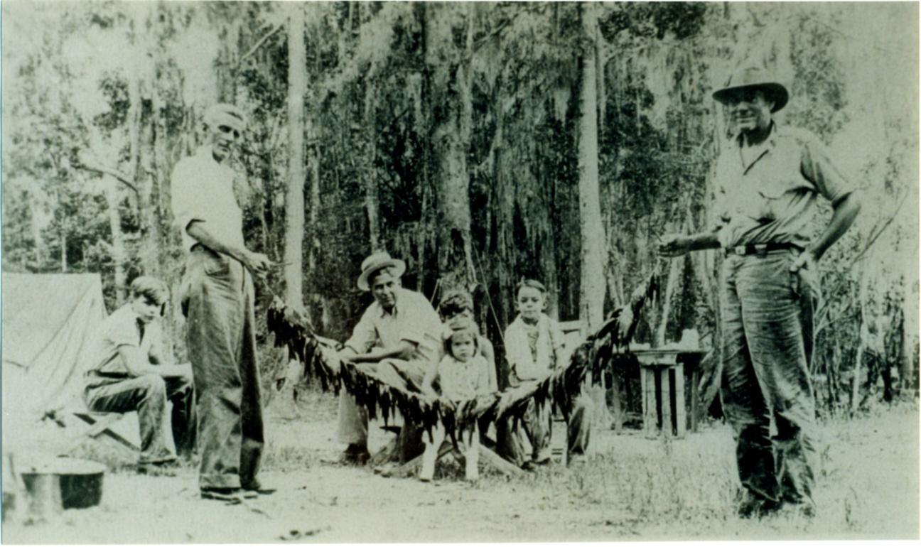 adults, children, and fish at camp on Santa Fe River