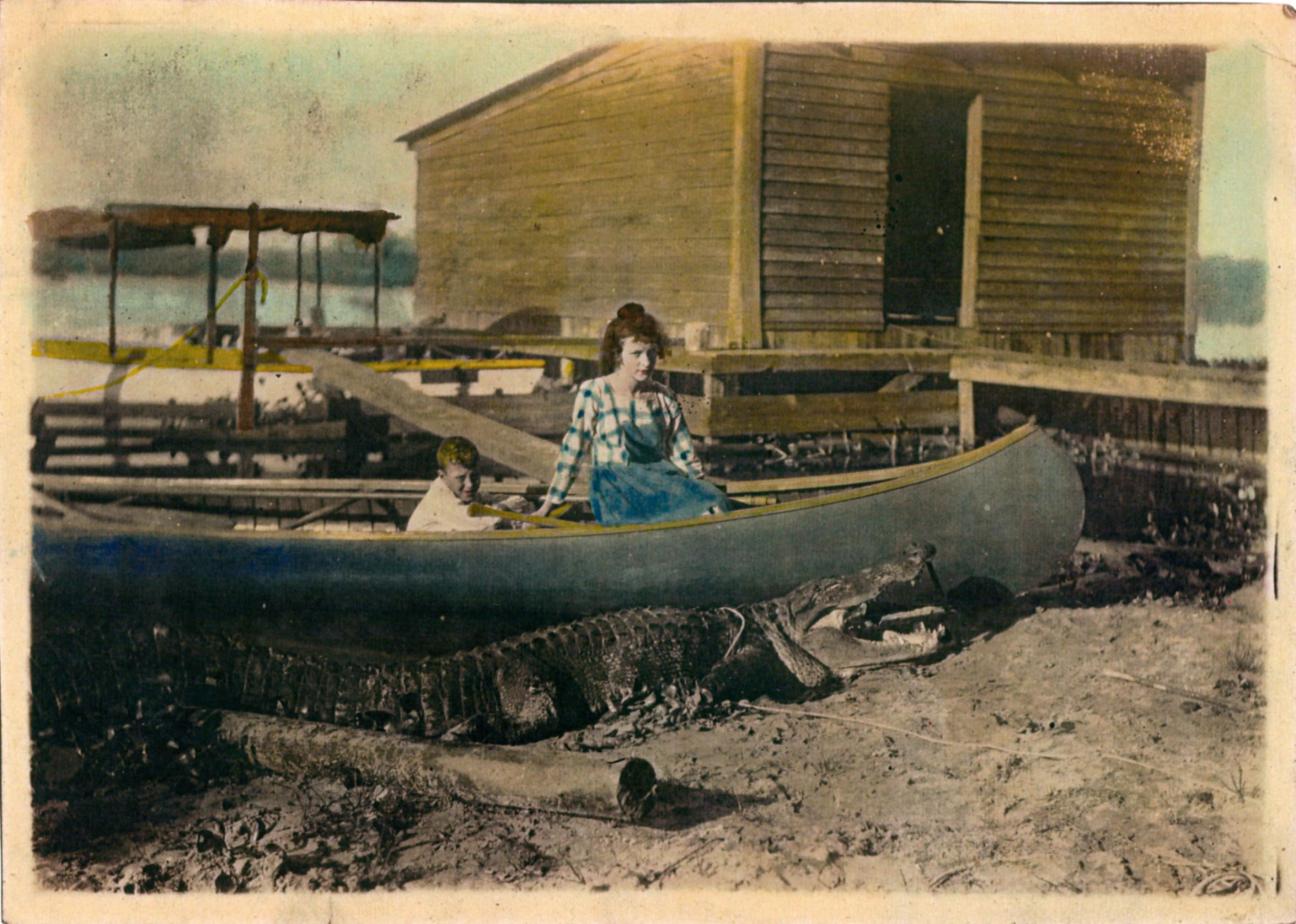 two Bell children in a canoe next to an alligator on Newnan's Lake