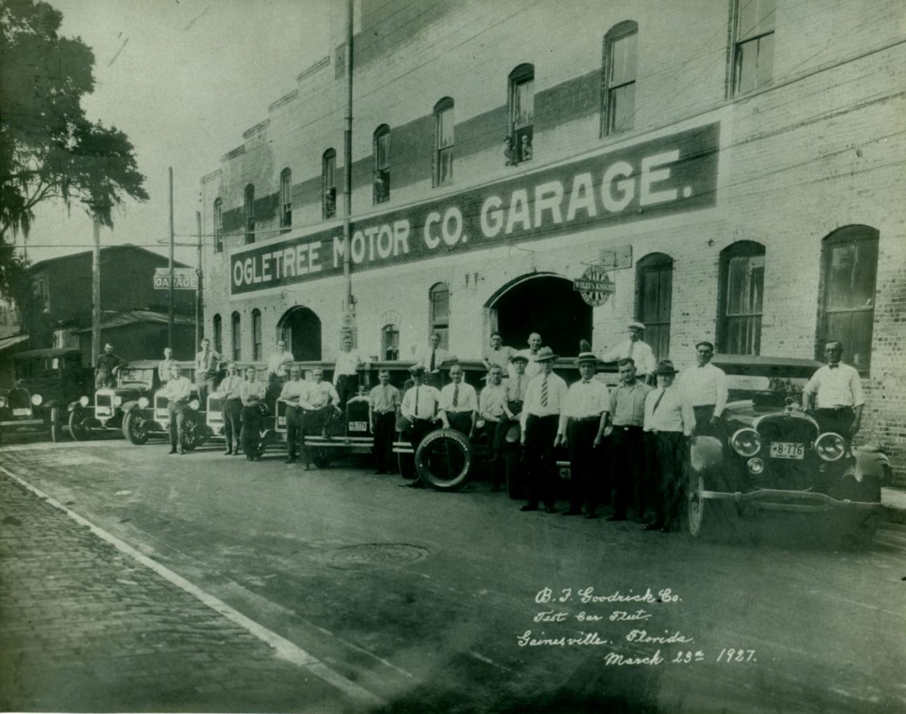 cars and men lined up in front of Ogletree Motor Co. Garage