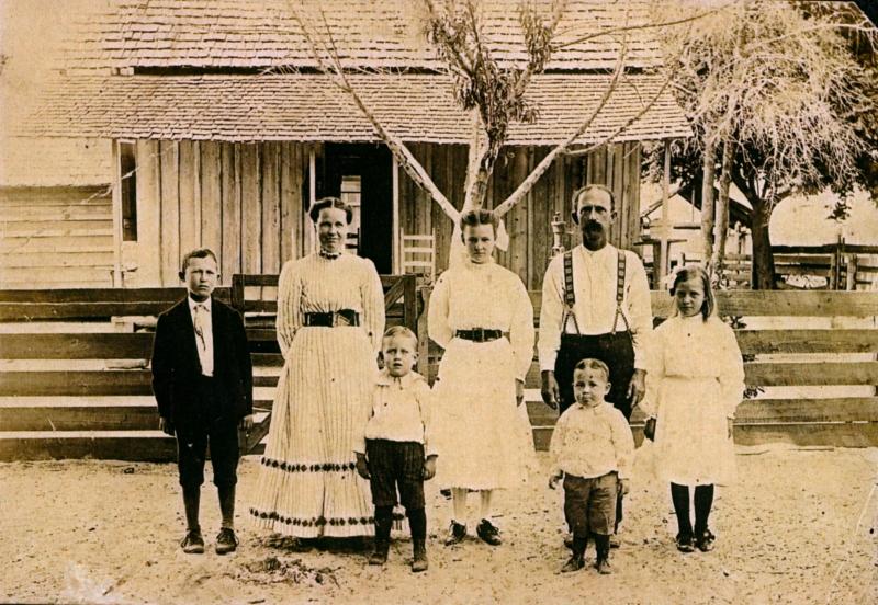 Anderson Family 3 adults and 4 children in front of old house