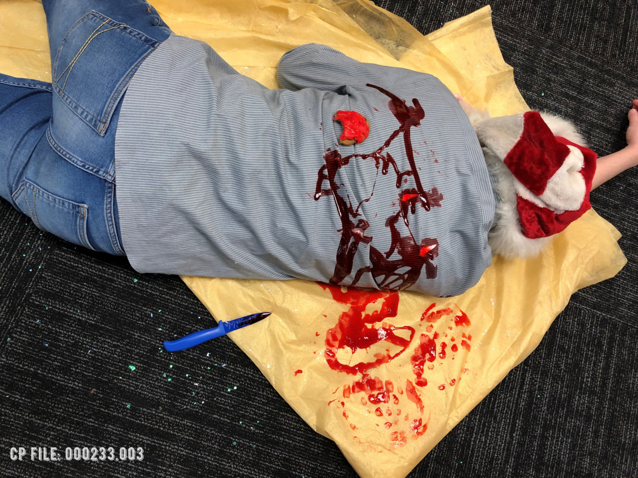 A close up of a dead body on top of a bloody tablecloth