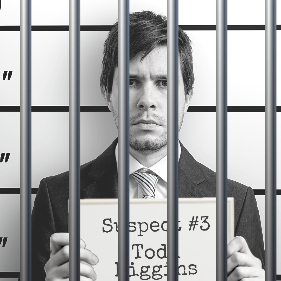 Black and white mugshot of a man in a business suit holding up a board that says "Suspect #3: Todd Higgins." There are bars over the photo.