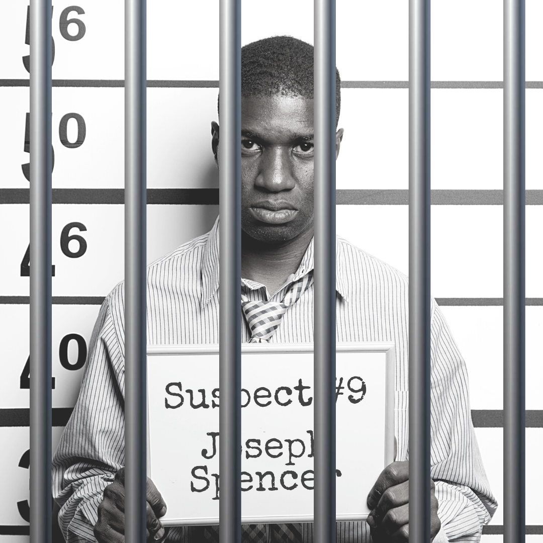 Black and white mugshot of a man in a button down shirt with a tie, holding a board that says "Suspect #9: Joseph Spencer." There are bars over the photo.