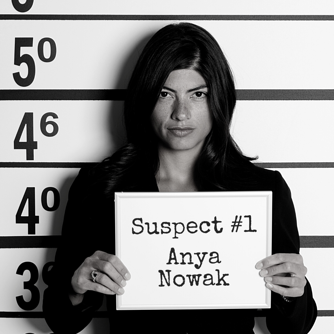 Suspect #1: Anya Nowak Black and white mugshot of a woman holding up a board that says "Suspect #1: Anya Nowak"