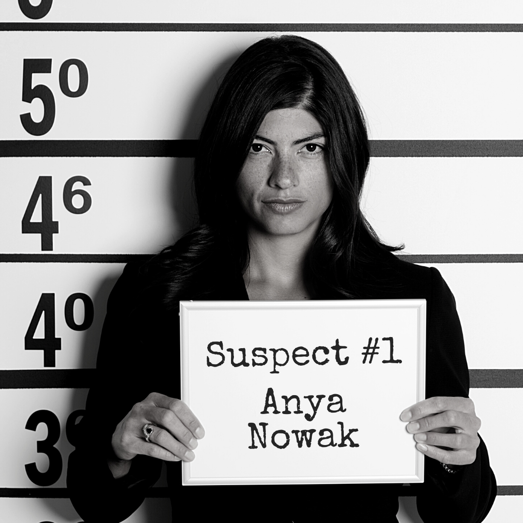 Black and white mugshot of a woman holding up a board that says "Suspect #1: Anya Nowak"