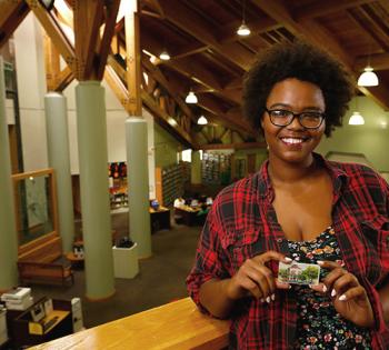 Woman holding a library card at Headquarters Library