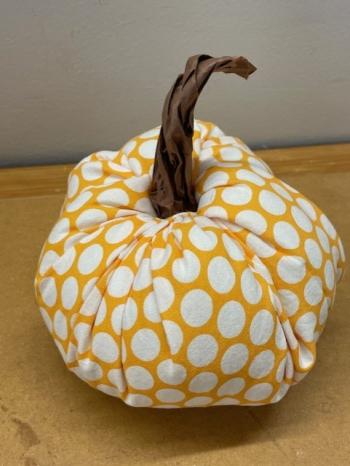 Image of a pumpkin made of orange & white polka dot fabric, and paper stem