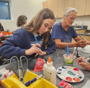 Image of a young girl & older woman painting full face masks